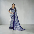 Mahalakshmi paradise floral printed blue saree with contrast border worn by a model with traditional gold jewellery.